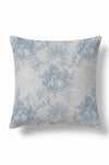 A square throw pillow featuring a classic blue floral toile de Jouy pattern on a textured off-white background, shown against a plain white studio backdrop.